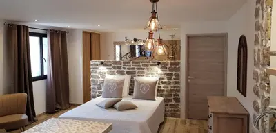 a bedroom with a bed and a stone wall at Maredda 2 in Sartène