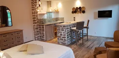 a room with a bed and a kitchen with a counter at Maredda 2 in Sartène