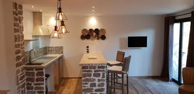 a kitchen with a counter and a table with chairs at Maredda 2 in Sartène