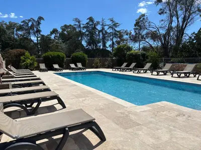a swimming pool with chaise lounge chairs next to it at Cardellini 4 in Sari Solenzara