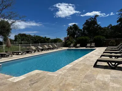 a swimming pool with chaise lounges and chairs at Cardellini 4 in Sari Solenzara