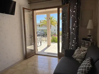 a living room with a couch and a sliding glass door at Cardellini 4 in Sari Solenzara