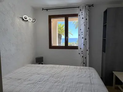 a bedroom with a bed and a window with scissors at Cardellini 4 in Sari Solenzara