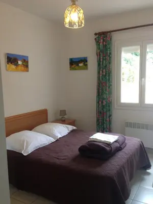 a bedroom with a bed with a purple blanket and a window at Villa Romarin in Partinello
