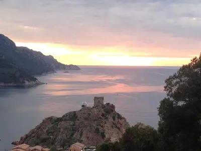 a castle on a small island in the water at Le monte rosso in Porto Ota