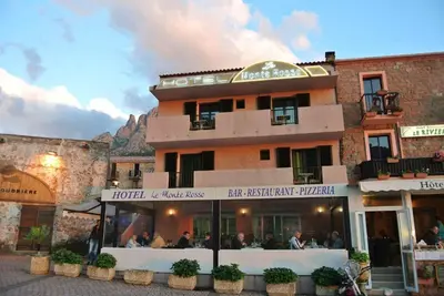a building with people sitting outside of it at Le monte rosso in Porto Ota