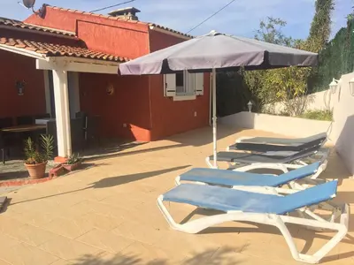 two lounge chairs and an umbrella on a patio at Corse Villa Porticcio vue Mer in Porticcio