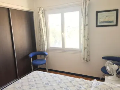 a bedroom with a bed and two chairs and a window at Corse Villa Porticcio vue Mer in Porticcio