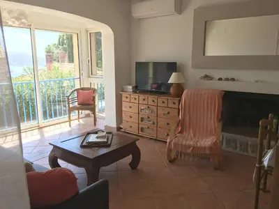a living room with a fireplace and a table at Corse Villa Porticcio vue Mer in Porticcio