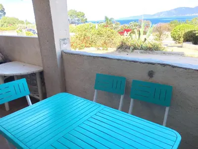 a blue bench and two chairs on a balcony at Vue mer panoramique plage 50m Porticcio Corse in Porticcio