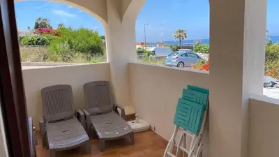 a balcony with two chairs and a toilet and a window at Vue mer panoramique plage 50m Porticcio Corse in Porticcio