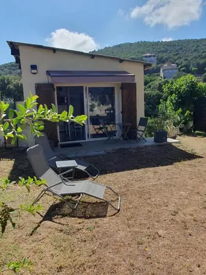 a pair of chairs sitting in front of a house at A CARDICCIA Loc saisonnières PIANA in Piana