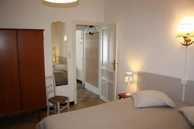 a bedroom with a white bed and a bedroom with a door at A CARDICCIA Loc saisonnières PIANA in Piana