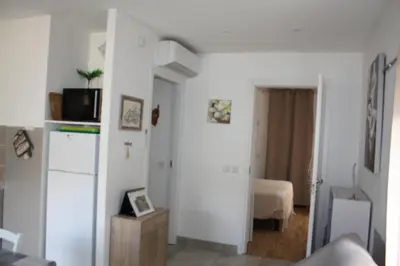 a white living room with a couch and a bed at A CARDICCIA Loc saisonnières PIANA in Piana