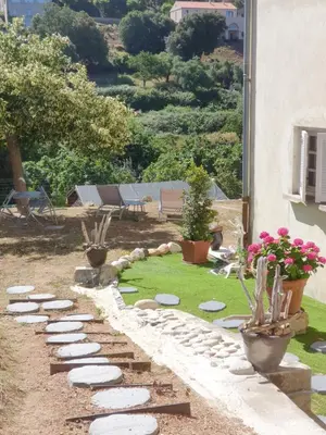 a garden with rocks and potted plants in a yard at A CARDICCIA Loc saisonnières PIANA in Piana