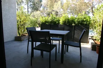 a table and chairs sitting on a patio at Résidence Terre et Mer in Sainte-Lucie de Porto-Vecchio