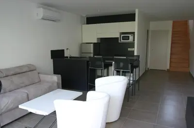 a living room with a couch and a table at Résidence Terre et Mer in Sainte-Lucie de Porto-Vecchio