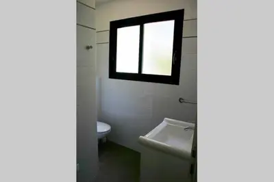 a bathroom with a toilet and a window at Résidence Terre et Mer in Sainte-Lucie de Porto-Vecchio