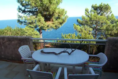 a table and chairs on a balcony with a view of the ocean at Asphodele in Tarcu