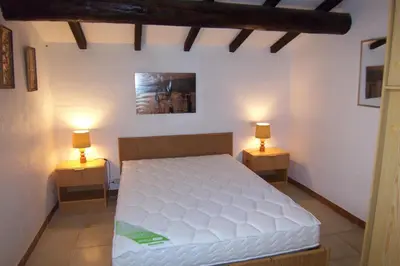 a bedroom with a white bed and two lamps on tables at Asphodele in Tarcu