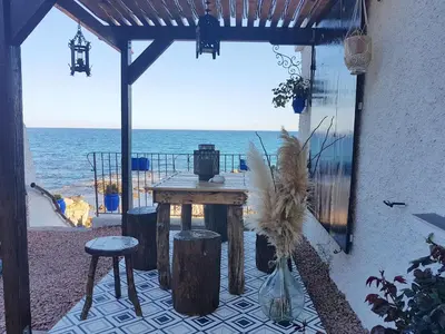 a patio with a table and a view of the ocean at Terra Rossa- clim- pieds dans l'eau in Conca
