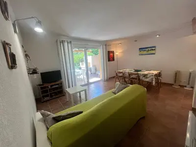 a living room with a green couch and a table at CEDRAT in Porto-Vecchio