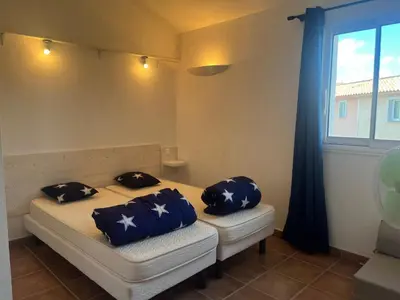two pillows on a bed in a room with a window at CEDRAT in Porto-Vecchio