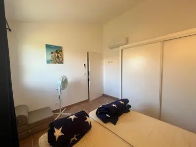a bedroom with a bed and a fan at CEDRAT in Porto-Vecchio