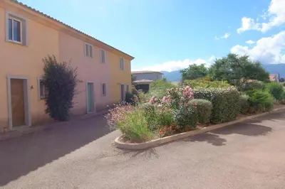 a building with a bunch of flowers in a yard at CEDRAT in Porto-Vecchio