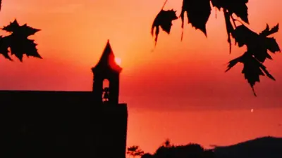a silhouette of a building with a clock tower at sunset at A Luna Rossa in Coti-Chiavari