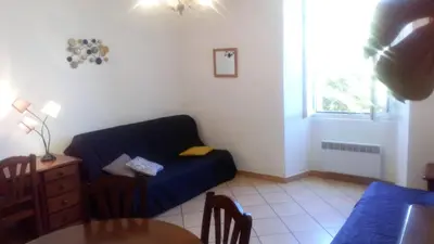 a living room with a blue couch and a table at A Luna Rossa in Coti-Chiavari