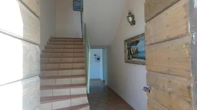a hallway with a wooden door and stairs at A Luna Rossa in Coti-Chiavari