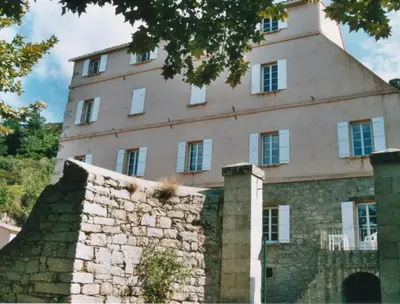 an old building with a tower on top of a stone wall at A Luna Rossa in Coti-Chiavari