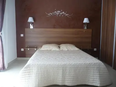 a bedroom with a large bed with a wooden headboard at Luna verde in Porto-Vecchio