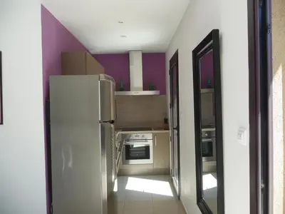 a kitchen with a white refrigerator and purple walls at Luna verde in Porto-Vecchio