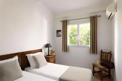 a bedroom with two beds and a window at Résidence Marina Rossa in Porto-Vecchio