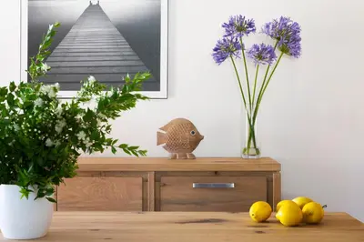 a table with a vase of purple flowers and some lemons at Résidence Marina Rossa in Porto-Vecchio