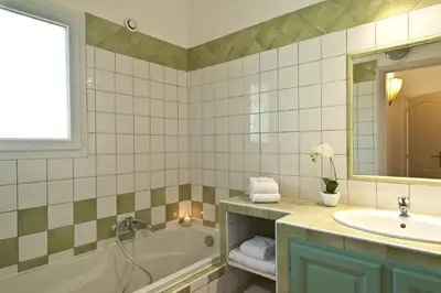 a bathroom with a tub and a sink and a mirror at Résidence Marina Rossa in Porto-Vecchio