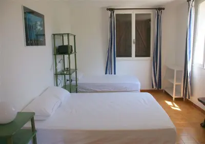 a bedroom with two beds and a window at Maja in Favone
