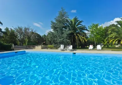 a large swimming pool with blue water in a yard at Domaine Valdaronu in Sainte-Lucie de Porto-Vecchio