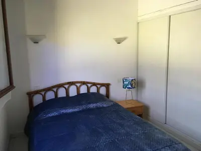 a bedroom with a bed with a blue comforter at Domaine Valdaronu in Sainte-Lucie de Porto-Vecchio