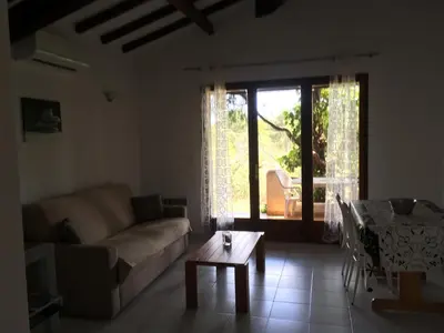 a living room with a couch and a table at Domaine Valdaronu in Sainte-Lucie de Porto-Vecchio