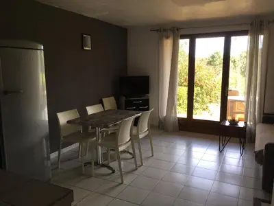 a kitchen and dining room with a table and chairs at Domaine Valdaronu in Sainte-Lucie de Porto-Vecchio