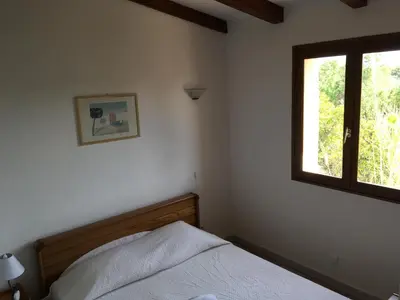 a bedroom with a bed and a window at Domaine Valdaronu in Sainte-Lucie de Porto-Vecchio