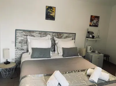a bedroom with a large bed with a brick wall at Hôtel U Passa Tempu in Corte