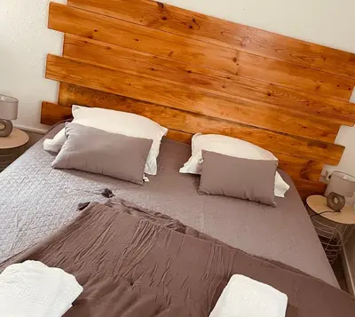 a bedroom with a large bed with a wooden headboard at Hôtel U Passa Tempu in Corte