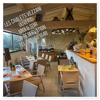 a dining room with tables and chairs in a restaurant at Gîtes les Chalets Vezzani Spa in Vezzani