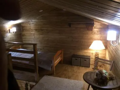 a room with two bunk beds and a table at Gîtes les Chalets Vezzani Spa in Vezzani