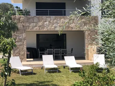 a group of chairs sitting in front of a stone wall at Sweet Holiday in Porto-Vecchio
