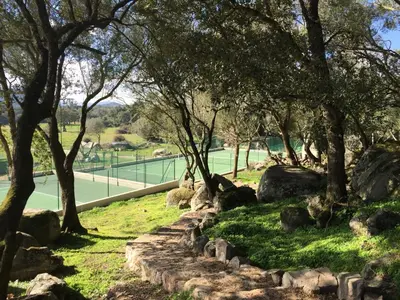 a park with rocks and trees and a tennis court at Sweet Holiday in Porto-Vecchio
